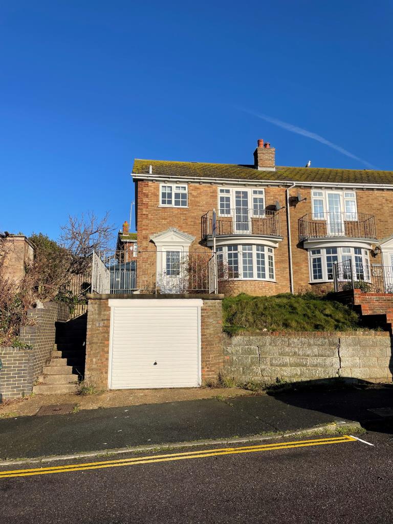 Lot: 93 - THREE-BEDROOM END-TERRACE HOUSE WITH GARAGE - Front shot of end terrace, yellow brick house with garage